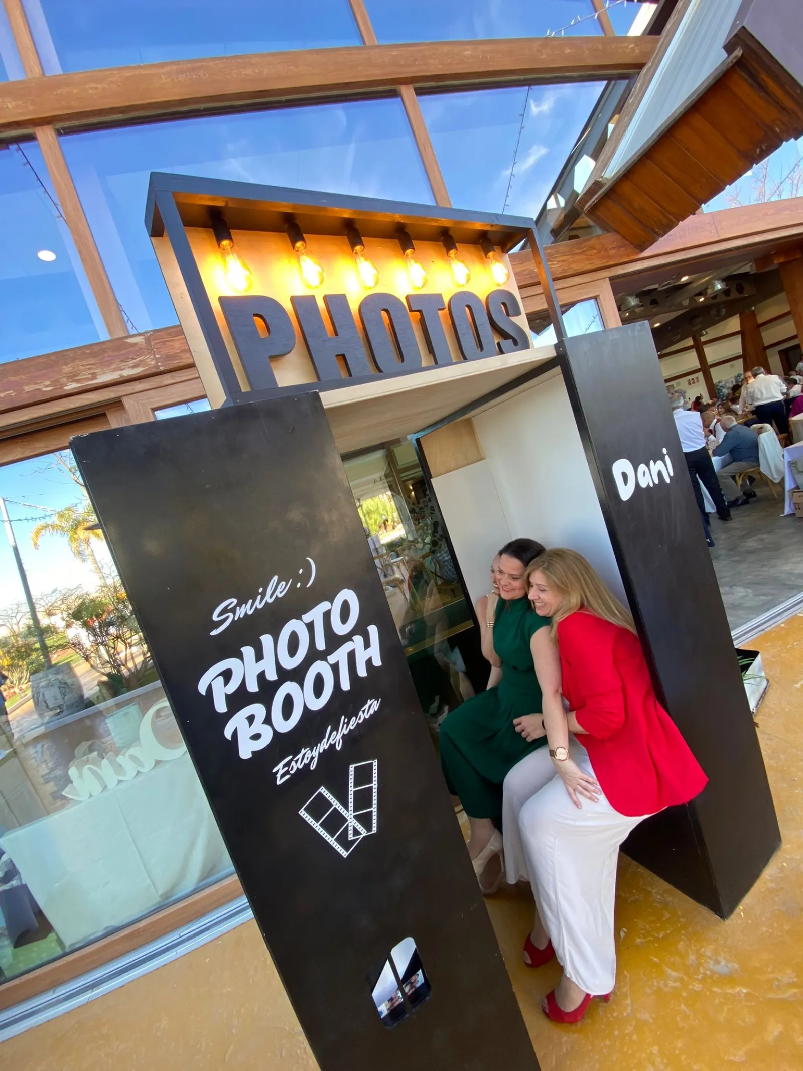 Cabina Street Photobooth con rótulo PHOTOS iluminado en una boda